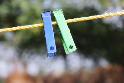 Close-up of clothespins hanging on rope