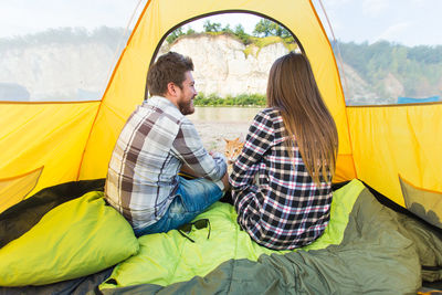 Young couple sitting on tent