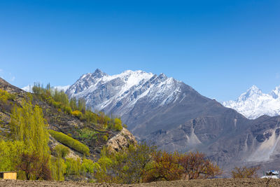 Scenic view of snowcapped mountains against clear blue sky