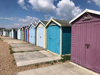 Beach huts by building against sky