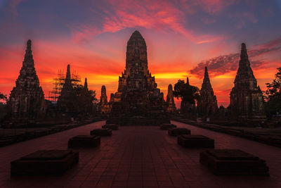Panoramic view of temple amidst buildings against sky at sunset