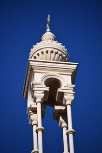 Low angle view of bell tower against blue sky