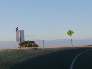 Road sign against sky