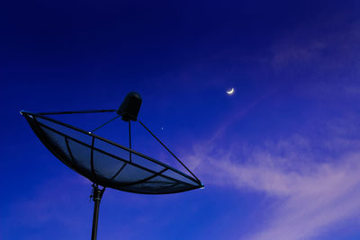 Low angle view of telephone pole against blue sky