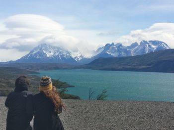 Rear view of friends looking at snowcapped mountains