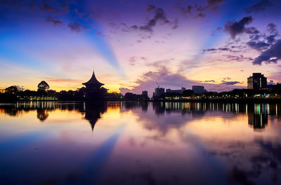 Reflection of temple in city at sunset