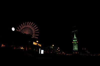 Low angle view of illuminated ferris wheel at night