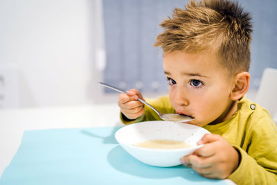 Portrait of boy holding ice cream on table