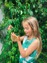 Low angle view of girl holding plant