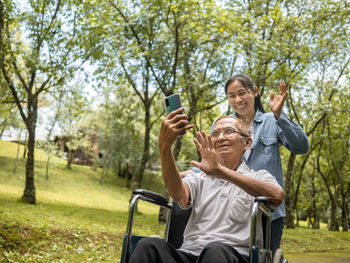 Man photographing with camera while sitting in park