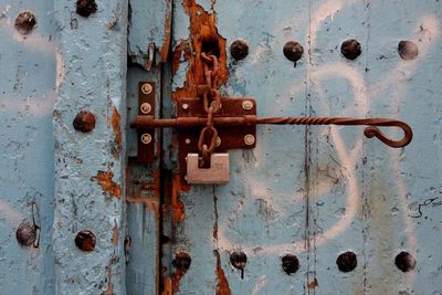 Close-up of rusty latch on old wooden door