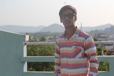 Man standing on building terrace against sky