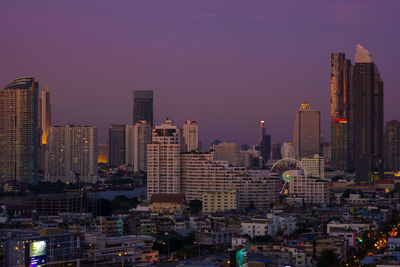 Illuminated buildings in city against sky