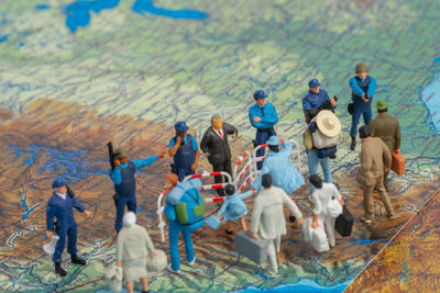 High angle view of figurines standing on map