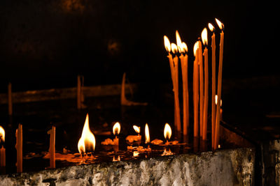 Burning candles in temple against building