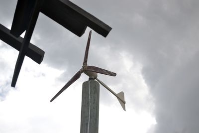 Low angle view of windmill against sky