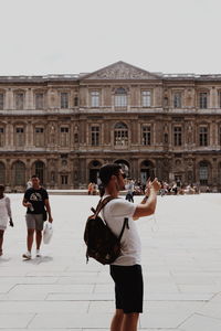 People photographing against sky in city