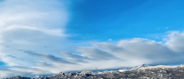 Scenic view of snowcapped mountains against blue sky