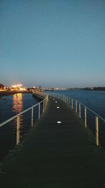 Pier on sea against clear sky