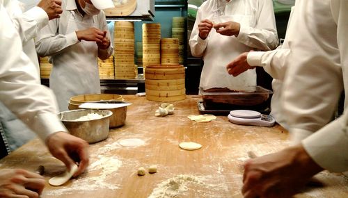 Chefs making dumplings in kitchen