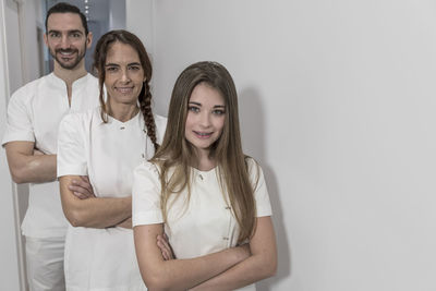 Portrait of smiling friends standing against white background