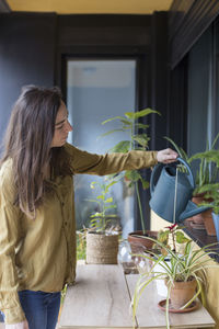 Woman holding potted plant at home
