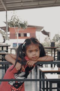 Portrait of girl standing against railing