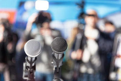 Close-up of microphone with people in background