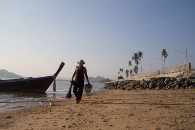 Man on beach against clear sky