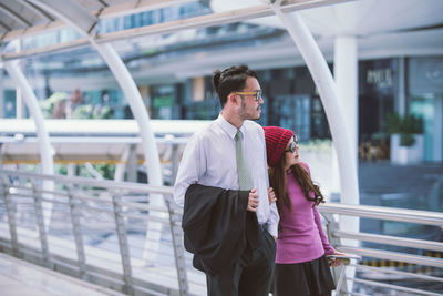 Full length of couple standing on railing