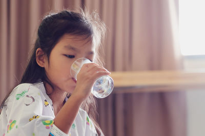 Portrait of a girl drinking water from glass