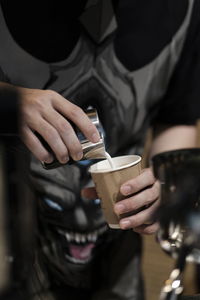 Midsection of man holding coffee cup