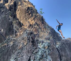 Full length of man jumping on rock