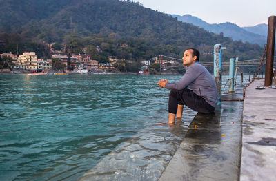 Rear view of man standing in water