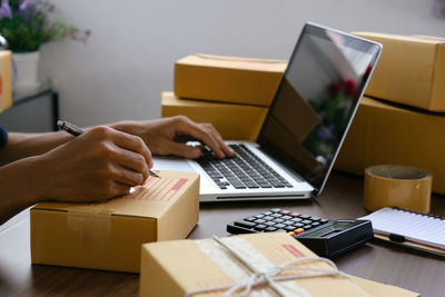 Midsection of woman using laptop on table