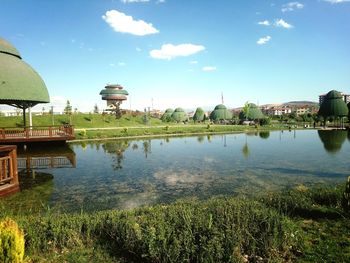 Scenic view of lake by buildings against sky