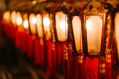 Close-up of illuminated lanterns hanging in row