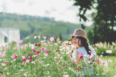 Woman with pink flowers on field