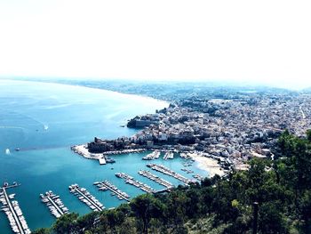 High angle view of city by sea against sky