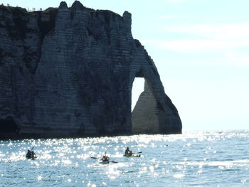 People in sea against sky