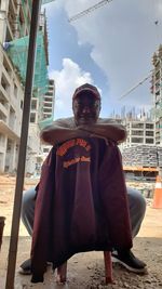 Portrait of man standing against sky in city