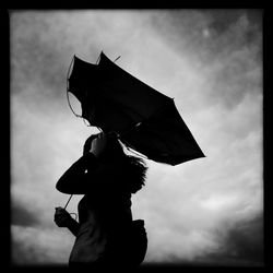 Low angle view of people against cloudy sky