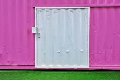 Closed white door of pink cabin