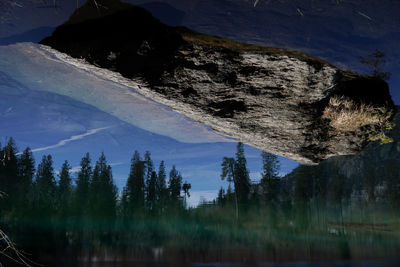 Panoramic shot of trees reflecting in lake cresta against sky