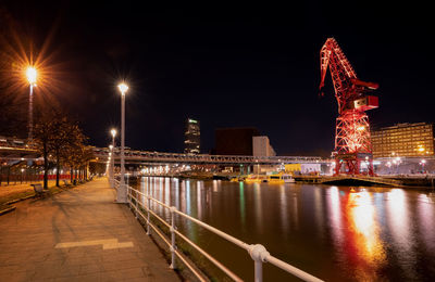 Illuminated bridge over river at night