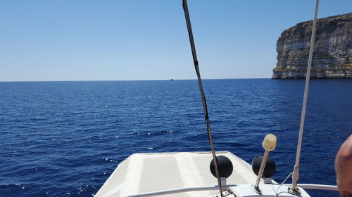 Sailboat sailing in sea against clear sky