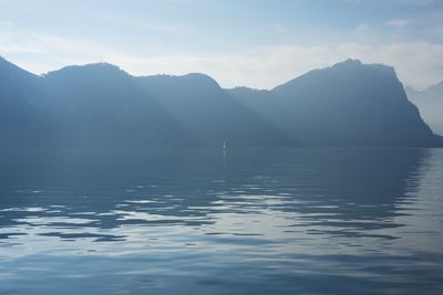 Scenic view of sea and mountains against sky