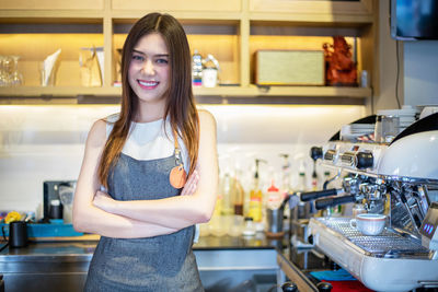 Portrait of smiling woman standing in kitchen