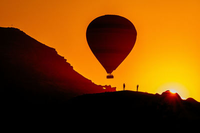 Silhouette of hot air balloon against sky during sunset