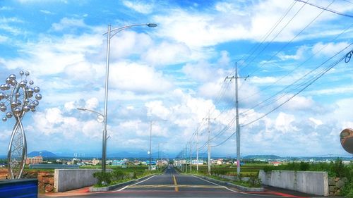 Electricity pylon against cloudy sky